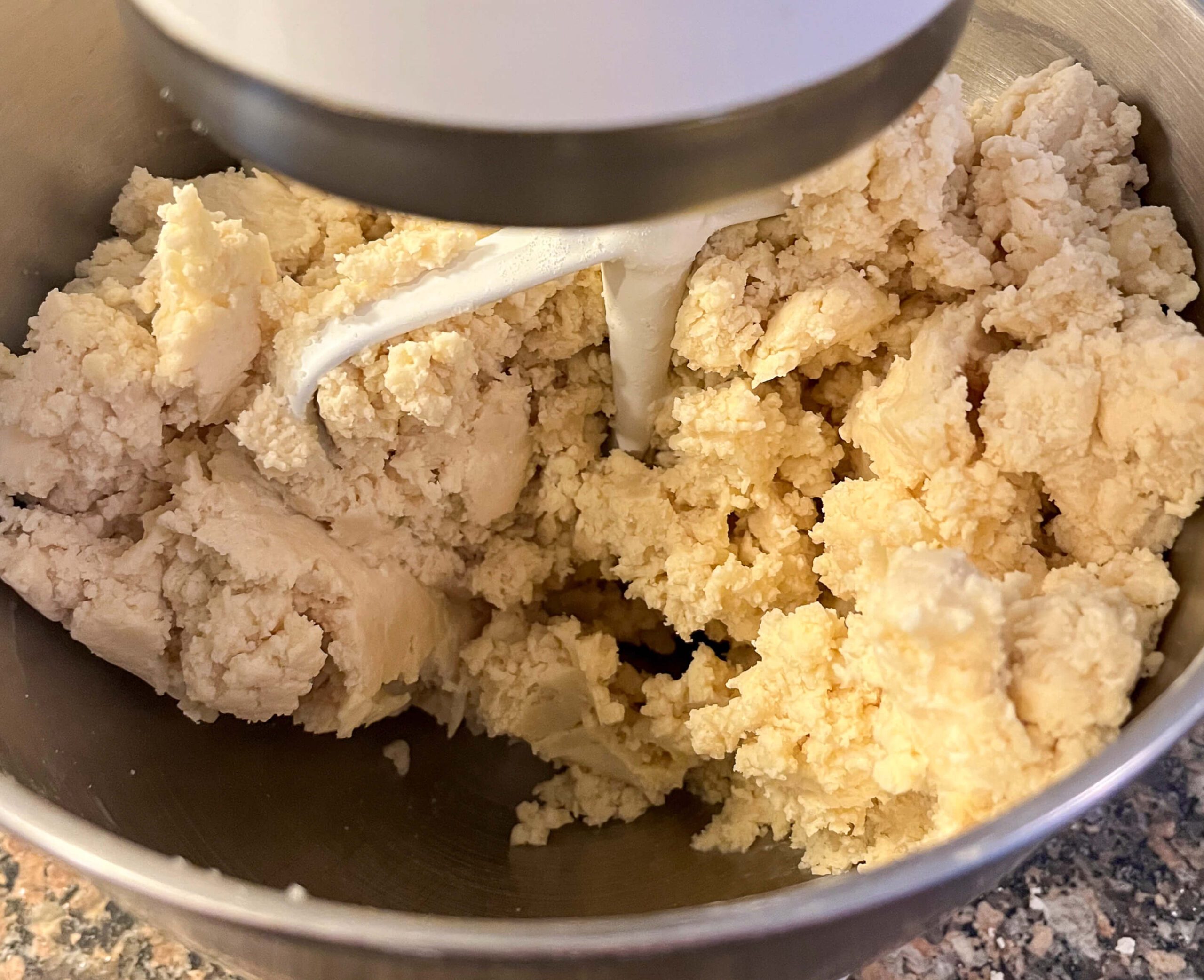 freshly mixed pie dough in a stand mixer