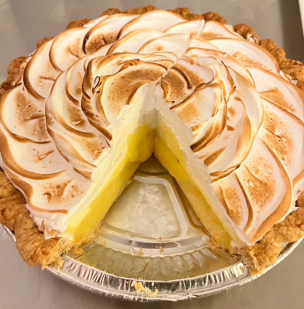 cross section of a lemon meringue pie with a slice removed