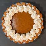pumpkin pie decorated with whipped cream