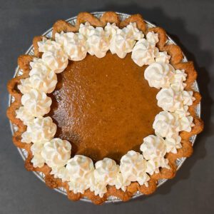 pumpkin pie decorated with whipped cream