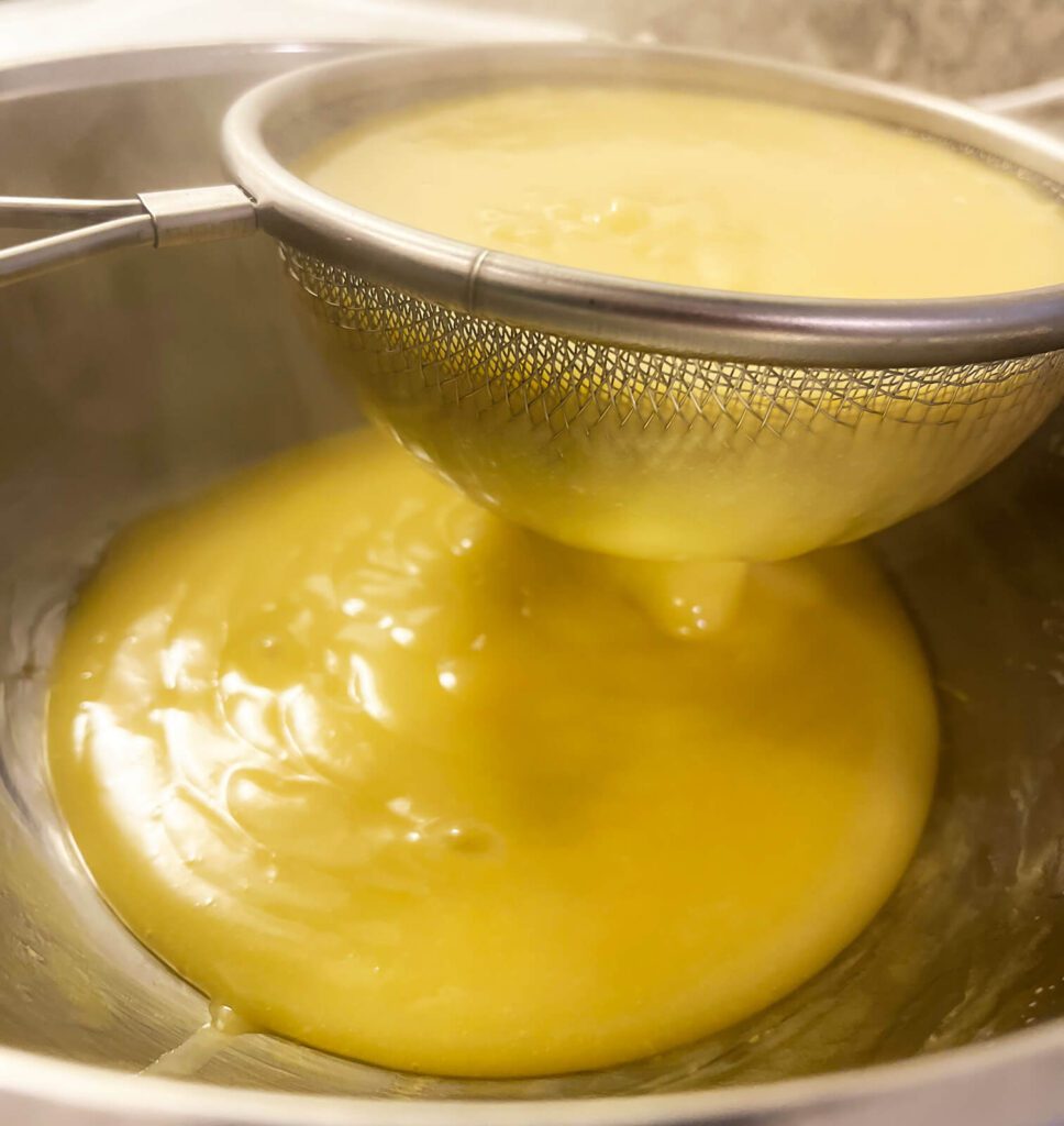 straining fresh lemon curd