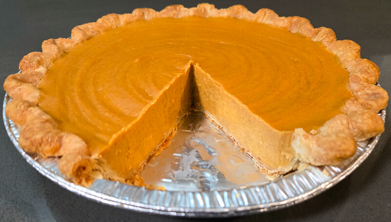 cross section of a brown butter sweet potato pie with a slice cut out