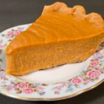 close up photograph of a slice of brown butter sweet potato pie in a flaky pie crust