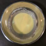 a photo of a mixing bowl with egg yolks, heavy cream, cornstarch, and salt mixed together before tempering the egg yolks