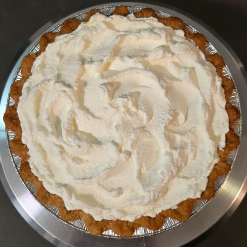 an overhead shot of a pie with whipped cream topping