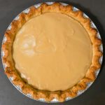 an overhead shot of a butterscotch pie with no topping after the butterscotch custard has set