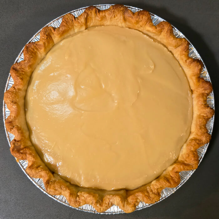 an overhead shot of a butterscotch pie with no topping after the butterscotch custard has set