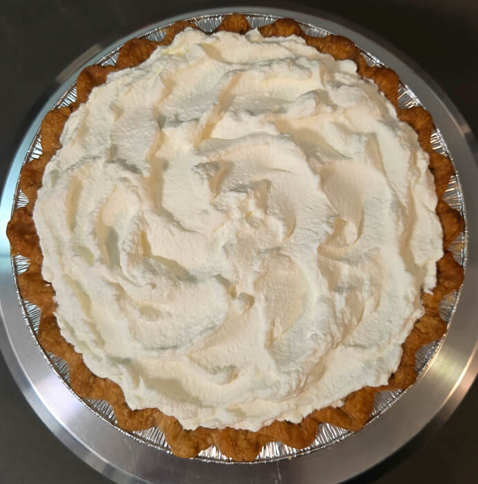 an overhead shot of a pie with whipped cream topping