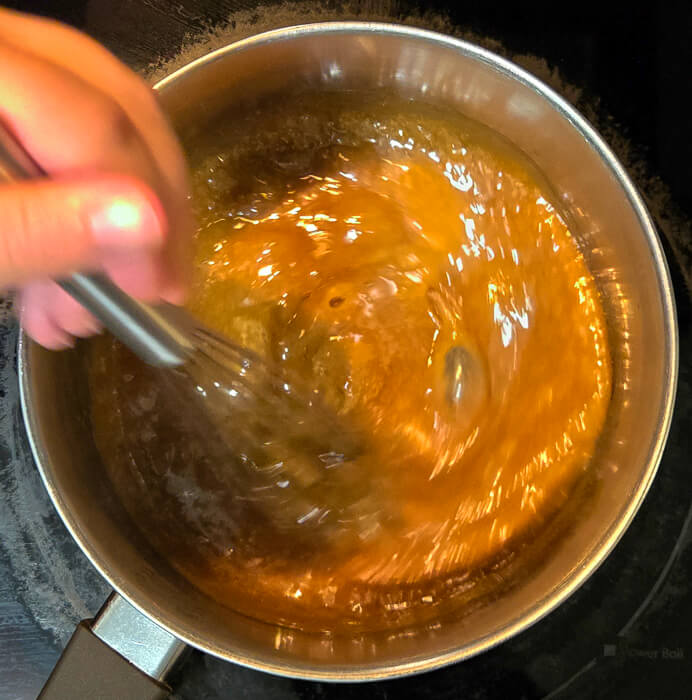 a photo of butterscotch being whisked together on a stovetop