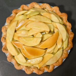 a picture of a pie shell with caramel apple pie filling inside, unbaked