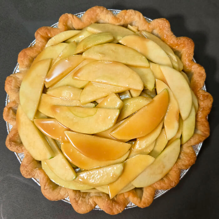 a picture of a pie shell with caramel apple pie filling inside, unbaked