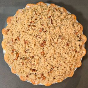 unbaked caramel apple pie with a pecan crumble topping ready to go in the oven