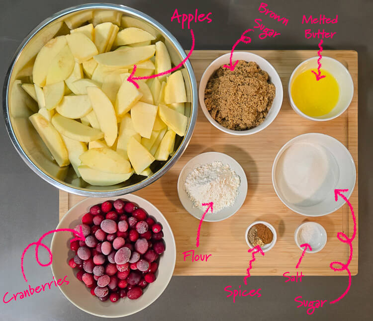 ingredients for cranberry apple pie: apples, brown sugar, melted butter, sugar, salt, spices, flour, and cranberries