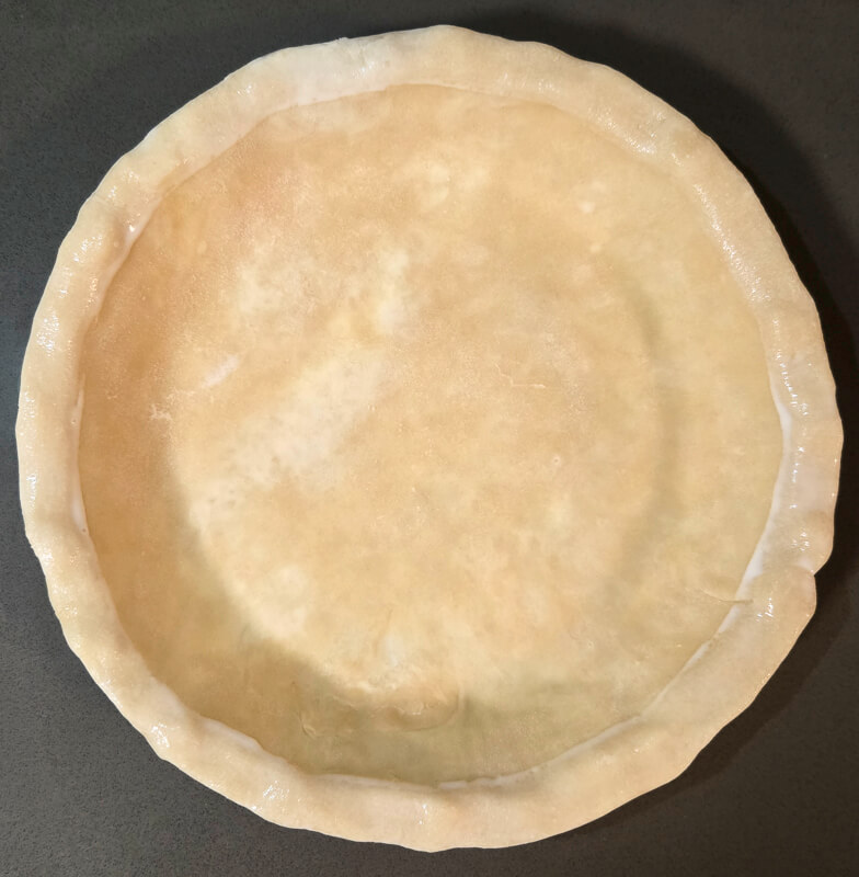 using cream to wet pie crust edges to attach decorations