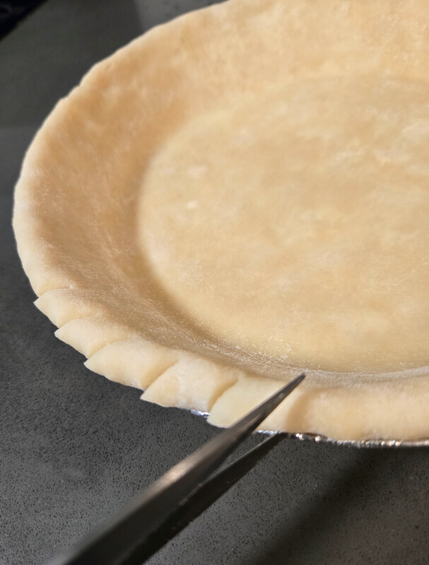 cutting the rolled edge of a pie crust
