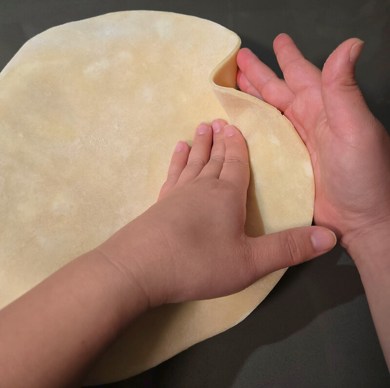 fitting pie dough into a pie tin