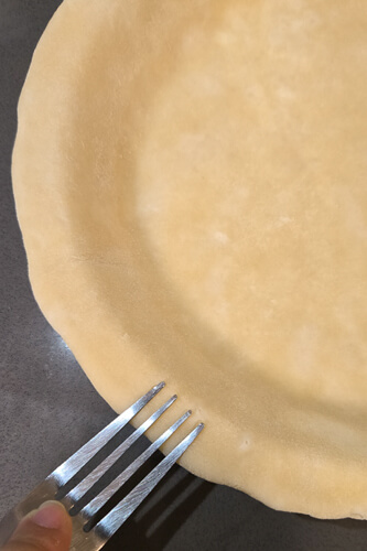 decorating the edge of a pie crust with a fork