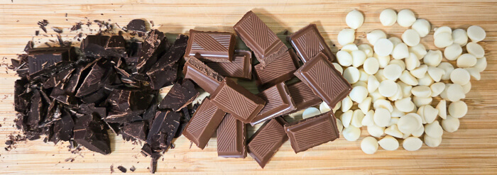 photograph of chopped bittersweet chocolate, milk chocolate, and white chocolate chips on a cutting board