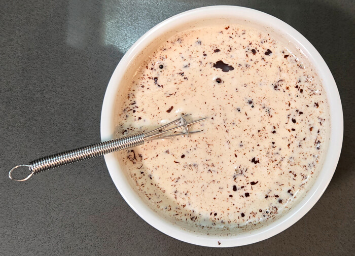 hot cream being added to chopped chocolate to make chocolate ganache
