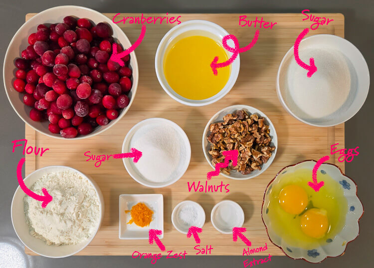Ingredients for Nantucket cranberry pie: cranberries, flour, melted butter, sugar (divided), walnuts, orange zest, salt, almond extract, and eggs