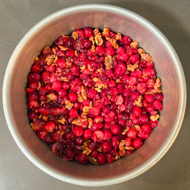 cranberries and walnuts pressed into the bottom of a cake pan