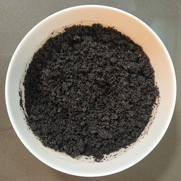 Oreo pi crust after mixing together Oreo crumbs and butter, before being pressed into a pie tin