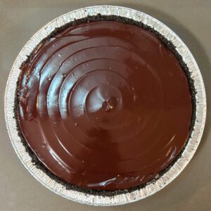 an overhead shot of a no-bake peanut butter pie in an oreo pie crust with a glossy chocolate ganache