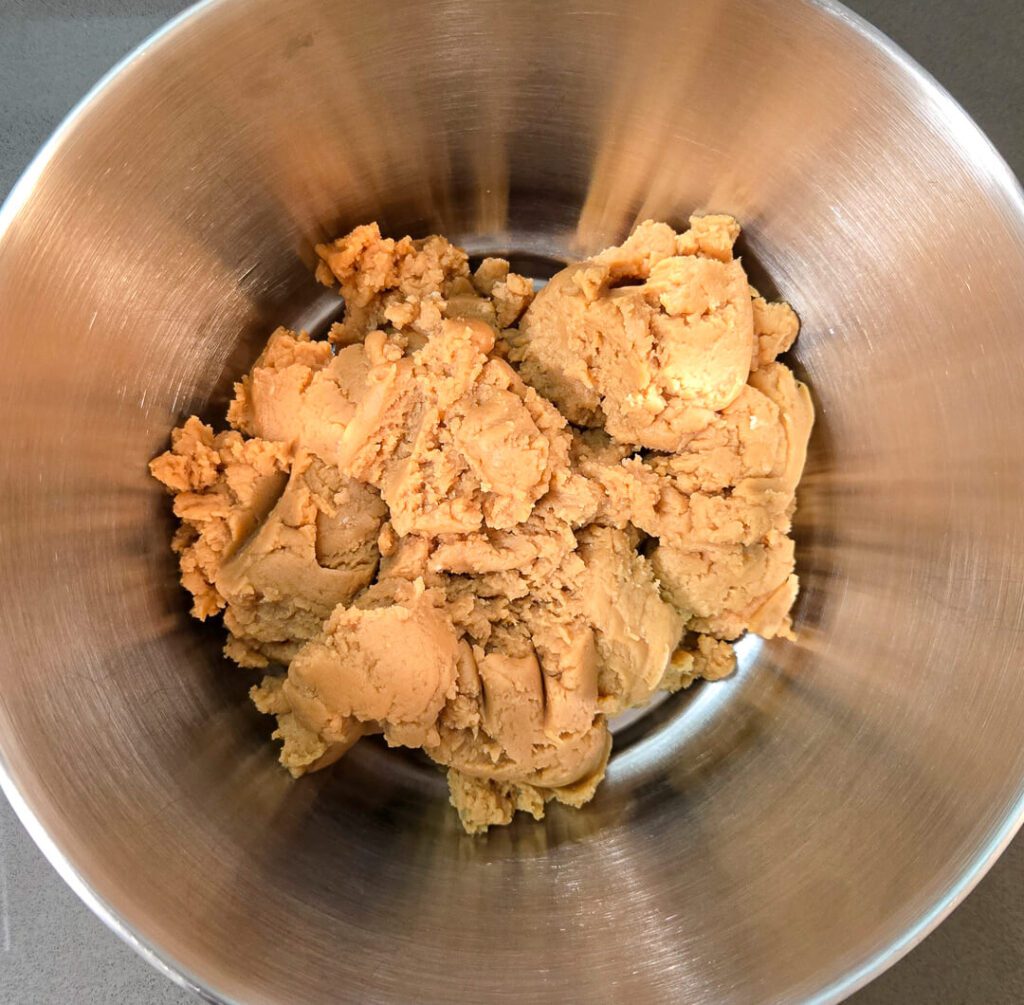 the first step for making peanut butter cheesecake. a mixture of peanut butter, powdered sugar, cream cheese, and vanilla.