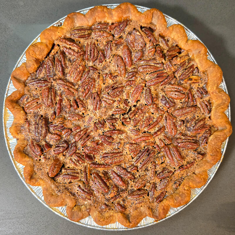 overhead photo of a pecan pie with a crimped pie crust