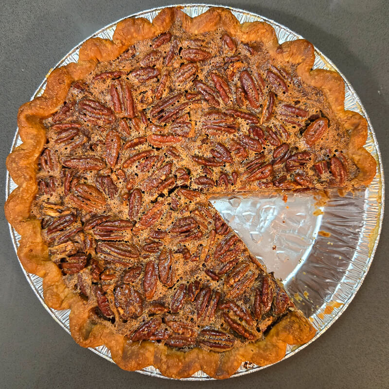an overhead view of a pecan pie with a slice cut out of it