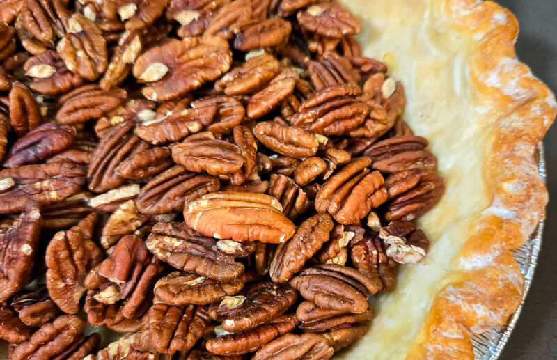 close up shot of pecans in a blind baked pie shell