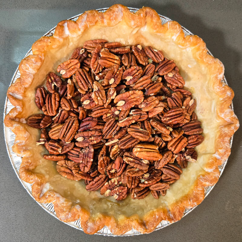 toasted pecan halves in a blind baked pie shell for pecan pie