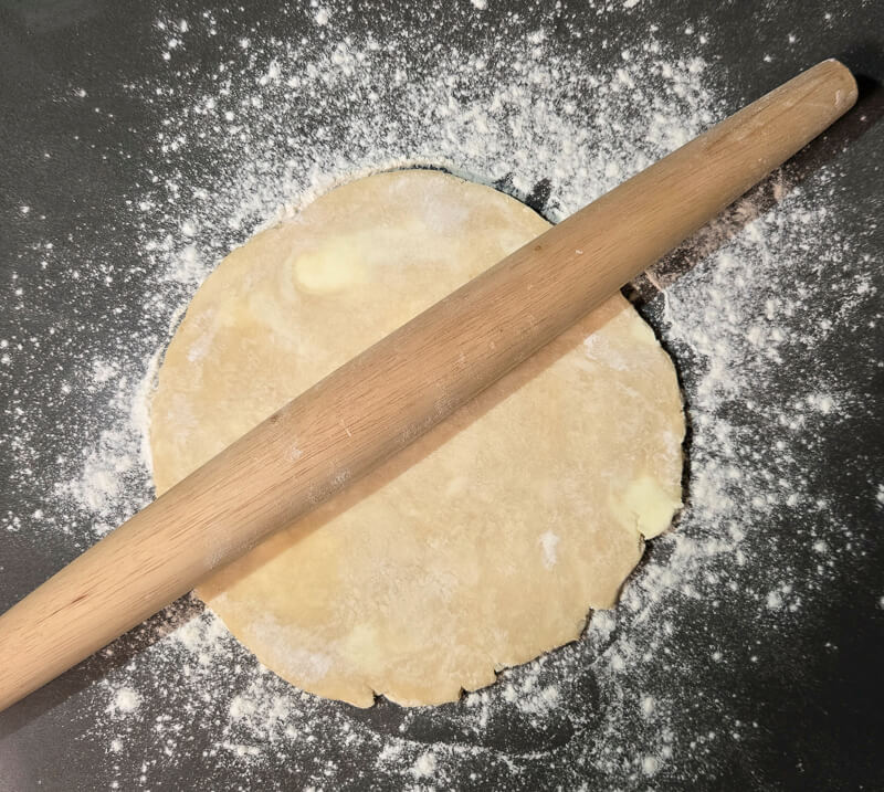 rolling out pie dough with a rolling pin