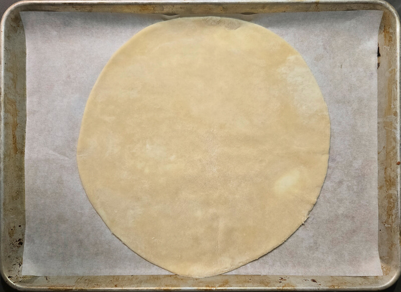 a rolled out circle of pie dough for a pie crust