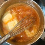 photo of a pot of caramel with butter being incorporated