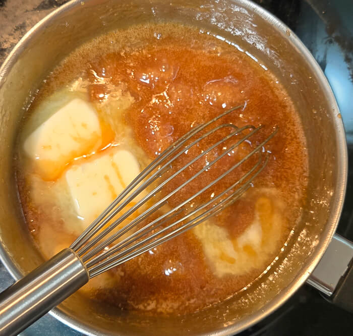 photo of a pot of caramel with butter being incorporated