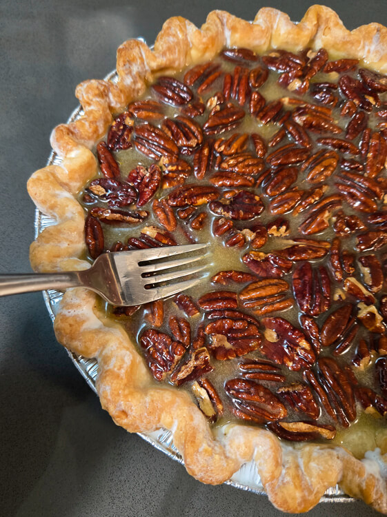 using a fork to dunk pecans in pecan pie filling so that the pecans don't burn