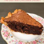 Slice of fudgy brownie pie with flaky crust on vintage floral plate, showing rich chocolate filling and crackly top.