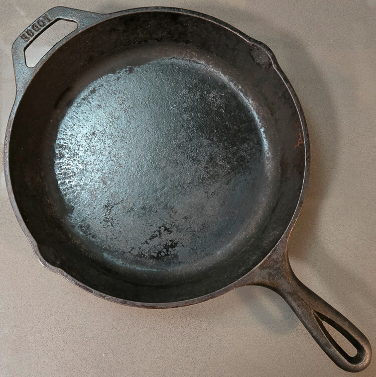 an overhead photo of a cast iron pan that needs to be reseasoned