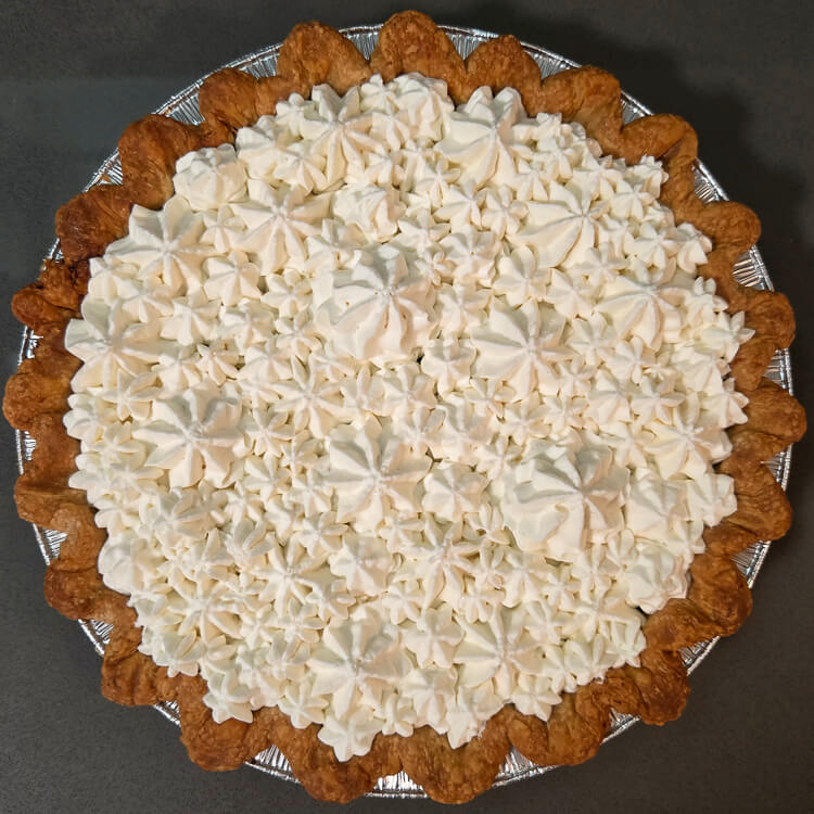 overhead view of a pie topped with piped whipped cream