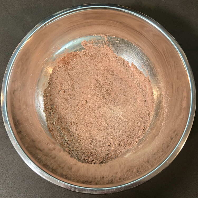 whisked dry ingredients for chocolate pudding in a bowl: corn starch, sugar, cocoa powder, and salt