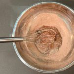 an egg slightly beaten with dry ingredients for chocolate pudding to prepare for tempering