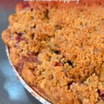 Cranberry apple pie with golden crumble topping in foil pie pan, Doggone Baking logo in corner.
