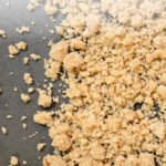 Overhead view of a homemade fruit pie with a golden crumble topping baked until crisp and buttery, sitting on a cooling rack ready to serve.