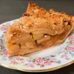 close up photo of a slice of Dutch apple pie on a floral plate