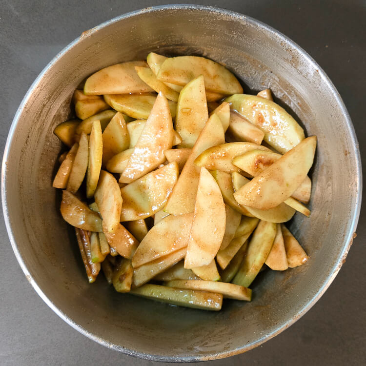 overhead photo of mixed apple pie filling in a mixing bowl