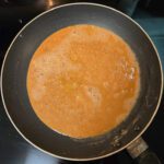 an overhead photo of a golden brown roux in a nonstick pan