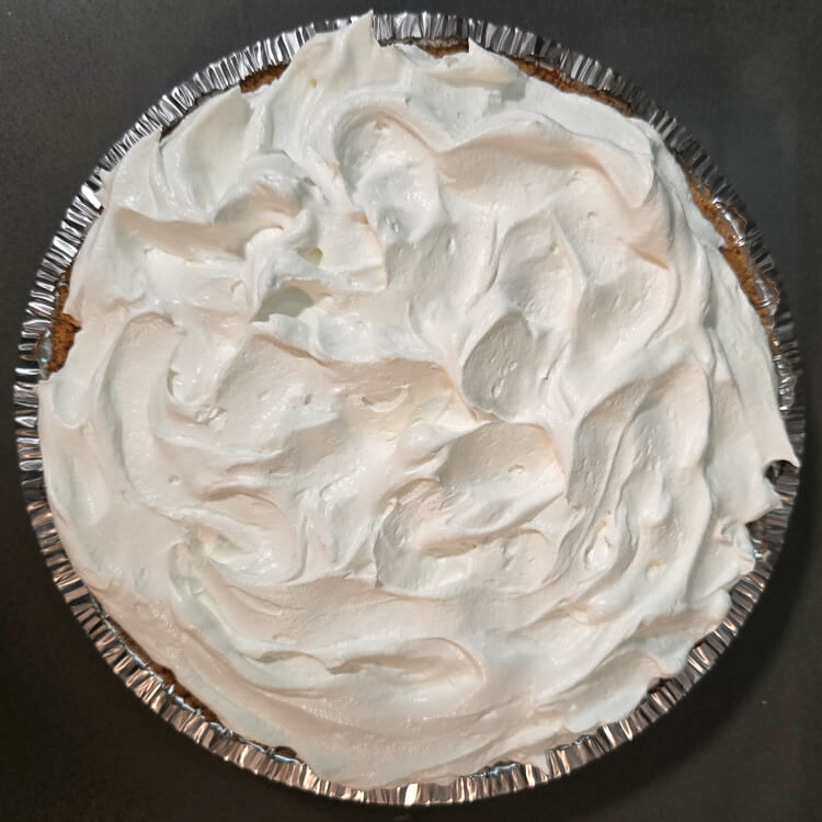 overhead photo of a pie in graham cracker crust topped with Cool Whip