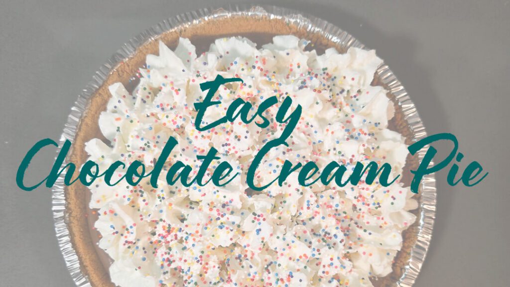 overhead photo of an easy chocolate cream pie decorated with whipped cream and rainbow sprinkles in a graham cracker crust with text overlay that reads "Easy Chocolate Cream Pie"