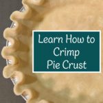 Top view of an unbaked pie crust with uniform scalloped crimps around the rim.